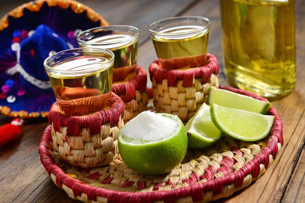 Mexican alcoholic drink known as tequila, accompanied by lemons and salt, a traditional way of consuming it in Mexico.