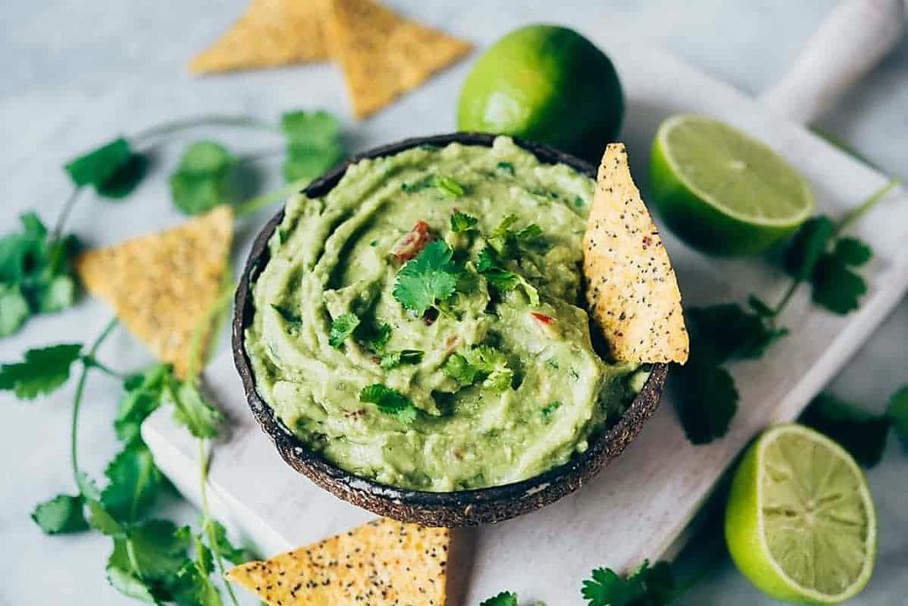 typical Mexican guacamole accompanied by tortilla chips.