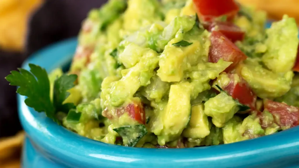 guacamole in a different presentation, with larger pieces of avocado, tomato, chile and onion, on a bowl to serve with tortilla chips
