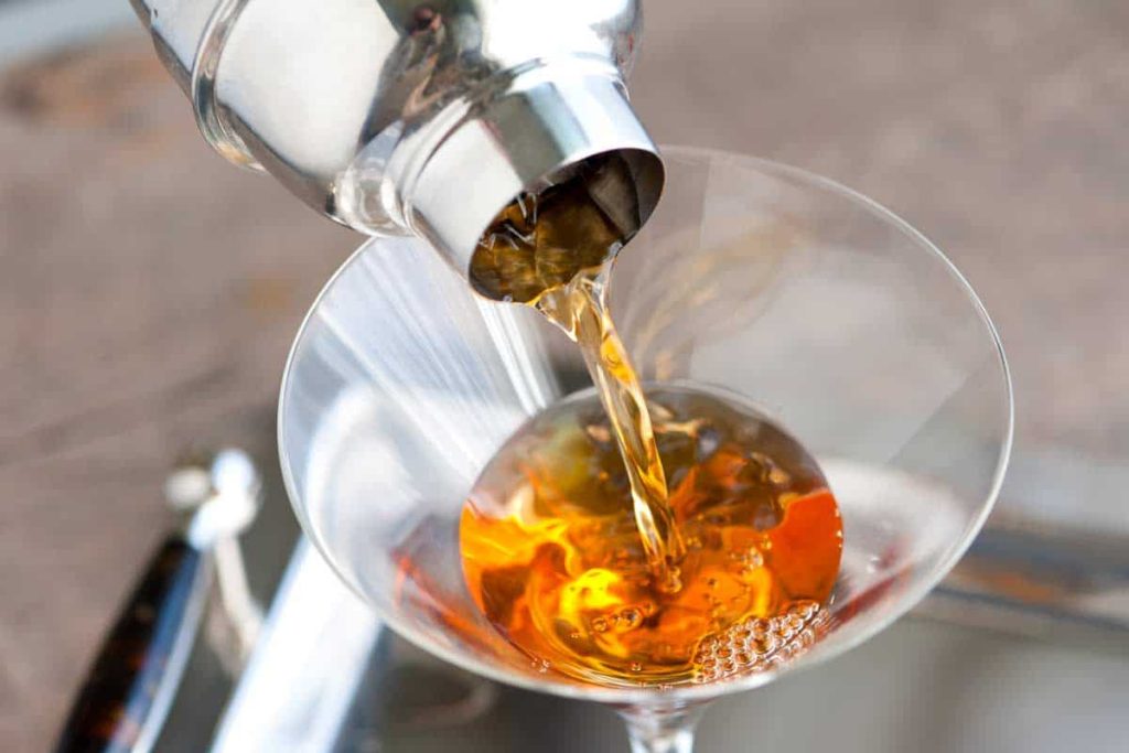 pouring whiskey for Manhattan Recipe