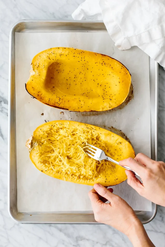 scooping seeds and pulp for Spaghetti Squash Recipe